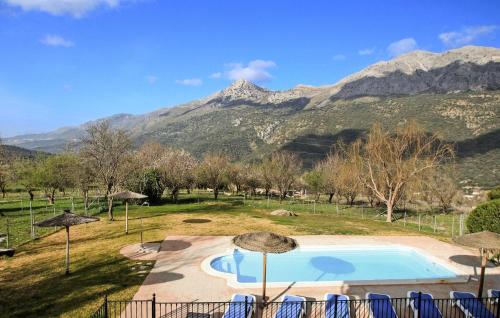 a swimming pool in a field with mountains in the background at Casa Rural Montion in Jimera de Líbar