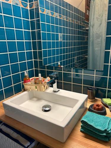 a bathroom with a white sink and blue tiles at La Villa Terracotta - Vue mer panoramique in Le Diamant