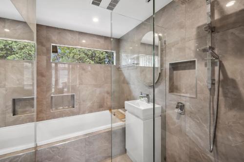 a bathroom with a shower and a toilet and a sink at Moonah on Mawson in Anglesea