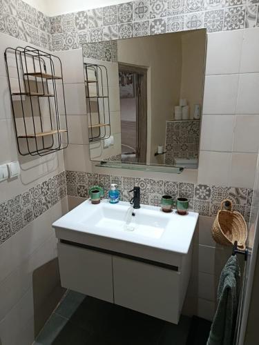 ein Badezimmer mit einem weißen Waschbecken und einem Spiegel in der Unterkunft Riad Asmaa Agadir in Agadir