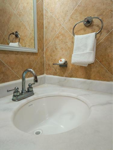 a bathroom sink with a mirror and a white towel at Hotel la Palapa Mazatlan in Mazatlán