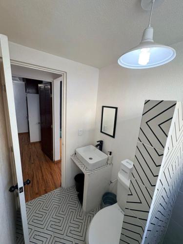 a bathroom with a toilet and a sink and a light at Soul Home in Momoxpan