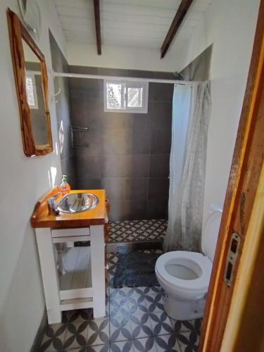 a small bathroom with a toilet and a sink at Casa Terra Monoambiente in El Bolsón