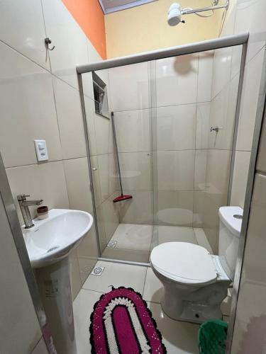 a small bathroom with a toilet and a sink at Casa da Mata in Ubatuba