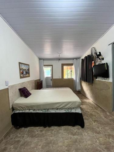 a bedroom with a large bed in a room at Casa da Mata in Ubatuba
