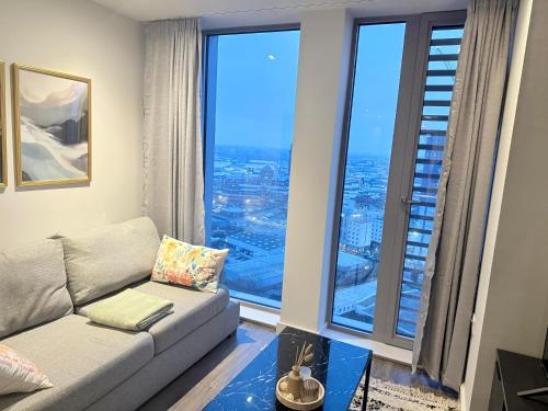 a living room with a couch and a large window at 2 bedroom APT in City Centre in Manchester