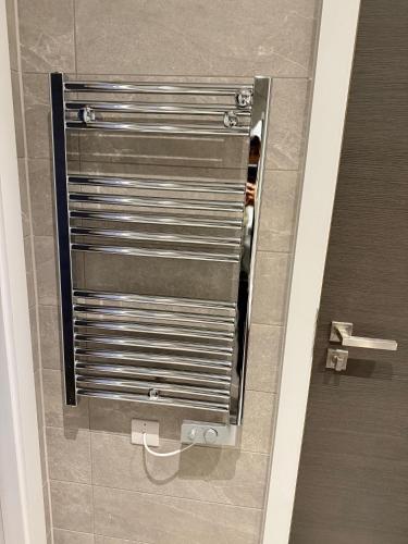 a bathroom stall with a metal door in a bathroom at 2 bedroom APT in City Centre in Manchester