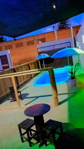 a pool with two chairs and two umbrellas at Pousada navarro in São Gabriel