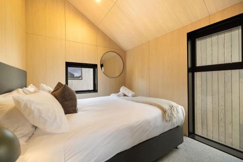 a bedroom with a large white bed with a window at Whetu Villa Queenstown in Queenstown