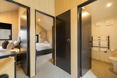 a bathroom with a glass door leading to a bedroom at Whetu Villa Queenstown in Queenstown