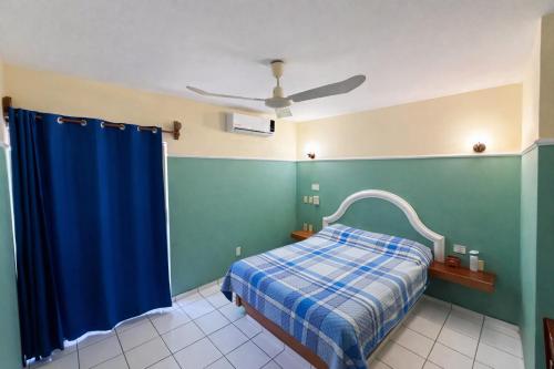 a bedroom with a bed and a blue curtain at Blue Pacific Suites in Mazatlán