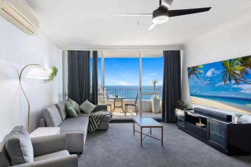 a living room with a couch and a view of the ocean at Golden Arcade - Views Games Vibes in Gold Coast