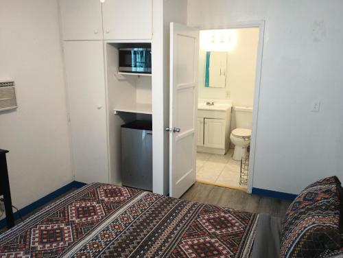 a bedroom with a bed and a bathroom with a toilet at Oceana Boutique Hotel in San Clemente