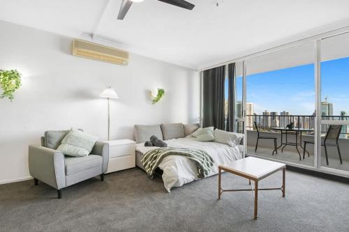 a living room with a bed and a couch and a table at Golden Arcade - Views Games Vibes in Gold Coast