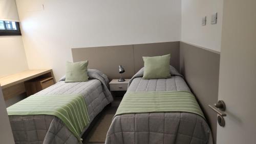 two beds in a small room with sidx sidx sidx sidx at Departamento macrocentro I, espacioso Río Cuarto in Río Cuarto