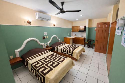 a hotel room with two beds and a kitchen at Blue Pacific Suites in Mazatlán