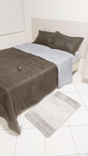 a bed sitting on a tiled floor in a bedroom at Recanto da Enseada in Guarujá