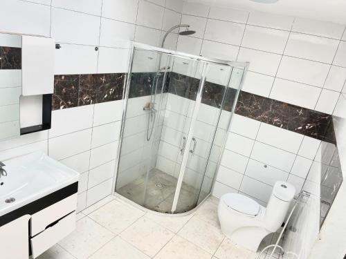 a bathroom with a shower and a toilet and a sink at Tranquil Stay Tunereng in Tujering