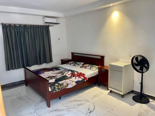 a bedroom with a bed and a desk and a fan at Tranquil Stay Tunereng in Tujering