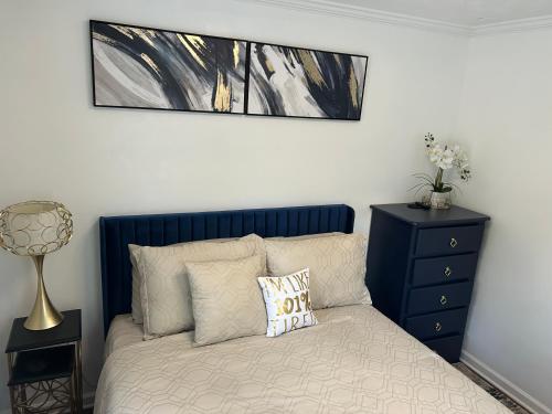 a bedroom with a bed with a blue head board at Hibiscus Retreat - Queen non smoking guest unit in Fayetteville