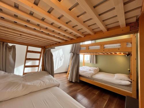 two bunk beds in a room with a ladder at SWELL in Hyuga
