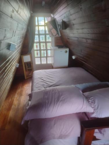 two twin beds in a room with a window at Chalé toca do tigre in Ponta Grossa