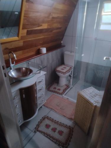 a bathroom with a toilet and a sink and a shower at Chalé toca do tigre in Ponta Grossa