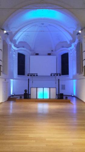 a large room with a wooden floor and a blue ceiling at Irish College Leuven in Leuven