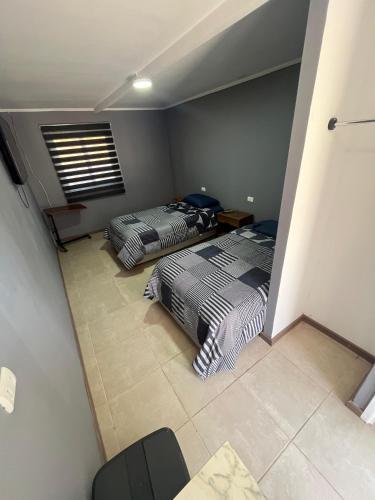 two beds sitting in a room with at Hostal JV Loft Doble A in Nogales