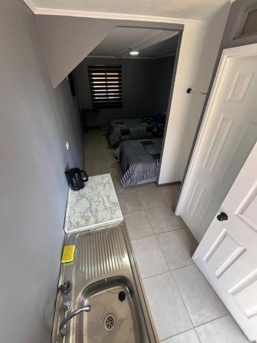 a bathroom with a sink and a couch in a room at Hostal JV Loft Doble A in Nogales