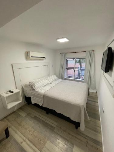 a small bedroom with a bed and a window at Karina Apartamentos in La Rioja