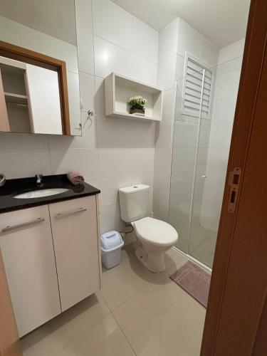 a white bathroom with a toilet and a shower at Estúdio Fit Caiobá - Matinhos in Matinhos