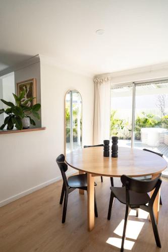 a dining room with a wooden table and chairs at Blueholes Beach Villa - Private Outdoor Space in Kalbarri