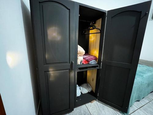 a black cabinet with its door open in a room at Loft D Mobiliado, individual com ar condicionado e garagem privada in Dourados