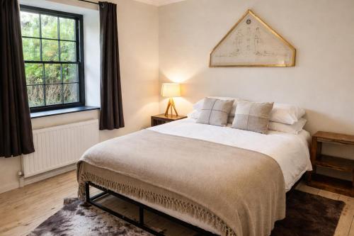 a bedroom with a large bed and two windows at Glandwr Lodge, 3 bed in Barmouth, Wales in Barmouth