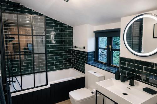 a bathroom with a tub and a toilet and a sink at Glandwr Lodge, 3 bed in Barmouth, Wales in Barmouth