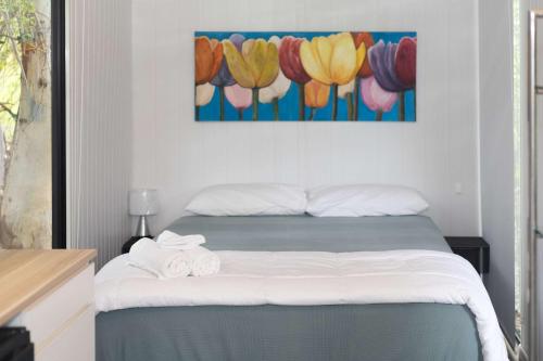 a bedroom with a bed with towels on it at Hill Creek Tiny House 5 by Tiny Away in Perwillowen
