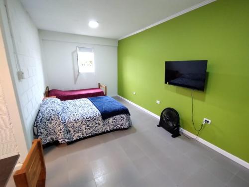 a bedroom with a bed and a flat screen tv at Dptos Ceci in Centenario