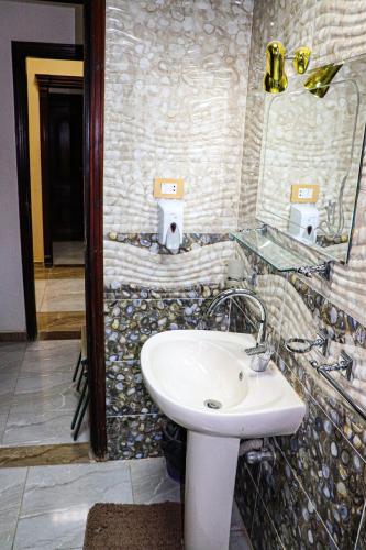 a bathroom with a sink and a mirror at Le-Printemps Hotel in Suez