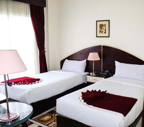 a hotel room with two beds with red decorations on them at Le-Printemps Hotel in Suez