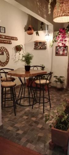 a table and chairs in a room with plants at Hosteria los Cristales in Santander de Quilichao