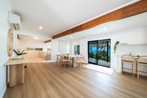 a living room with a table and a dining room at Broadwater Breeze in Airlie Beach