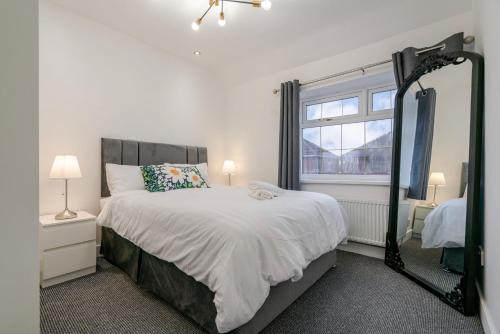 a bedroom with a large bed and a mirror at Spacious 4 bed Ideal for Business & Long Term Stays, Free Parking in Manchester