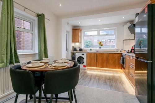 a kitchen with a table and chairs in a room at Spacious 4 bed Ideal for Business & Long Term Stays, Free Parking in Manchester
