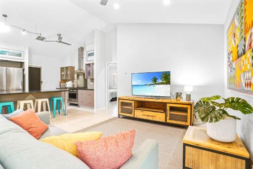 a living room with a couch and a tv at Beachfront Serenity Family Home at Wonga Beach in Wonga