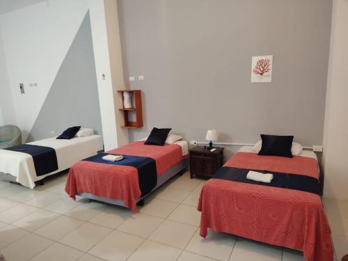 a room with two beds with red and black sheets at Misha Home Nro 732 in Puerto Ayora