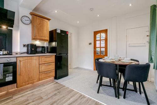 a kitchen with a table and chairs in a room at Spacious 4 bed Ideal for Business & Long Term Stays, Free Parking in Manchester