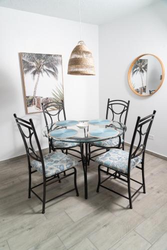 una sala da pranzo con tavolo e sedie in vetro di Beachfront Wave at Isla Verde a San Juan