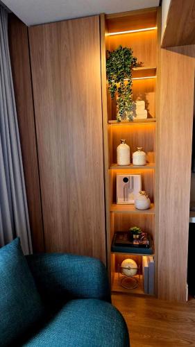 a living room with a blue couch and a book shelf at Studio Lumière Moema in São Paulo