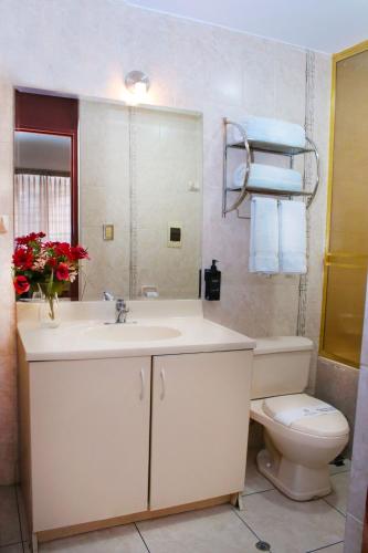 a bathroom with a sink and a toilet and a mirror at Hoteles Riviera Cayma in Arequipa
